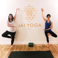 Jai Yoga Studio - Yogis posing with the Jai Yoga logo in the yoga room of Jai Yoga Studio