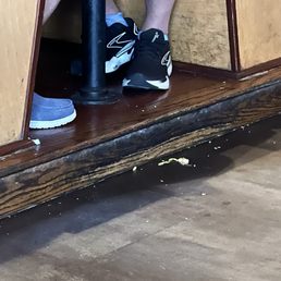 These people had just been seated and there was food leftover on the floor from previous patrons. A very unclean restaurant These people had just been seated and there was food leftover on the floor from previous patrons. A very unclean restaurant