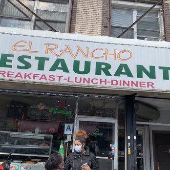 El Rancho Dominicano - a woman in a face mask standing in front of a restaurant - Dominican Near Me - Brooklyn, New York El Rancho Dominicano - a woman in a face mask standing in front of a restaurant - Dominican Near Me - Brooklyn, New York