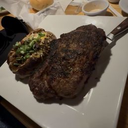 Ribeye steak bone in and loaded baked potato Ribeye steak bone in and loaded baked potato