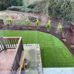 Concrete pad, artificial turf, new bark, trees, and shrubs. Concrete pad, artificial turf, new bark, trees, and shrubs.