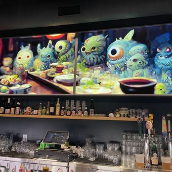 Yokai - The fun, crazy-town art hanging over the bar at Yokai. - Ramen Near Me - Greensboro, North Carolina