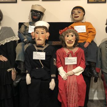 Vent Haven Museum - Multiple vintage ventriloquist puppets with detailed facial expressions and period clothing are displayed on a wall at Vent Haven Museum. The puppets include figures dressed as a sailor, a nurse, a soldier, and others, each with a label describing their background. The display highlights the history and craftsmanship of ventriloquism memorabilia. - Museums Near Me - Ft Mitchell, Kentucky