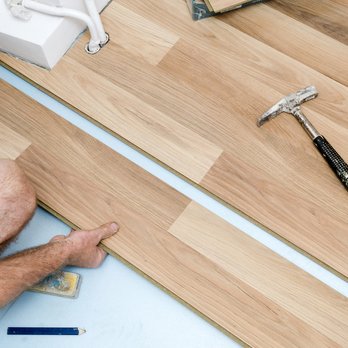 Duncan Remodeling - a man laying laminate on the floor - Flooring Near Me Duncan Remodeling - a man laying laminate on the floor - Flooring Near Me