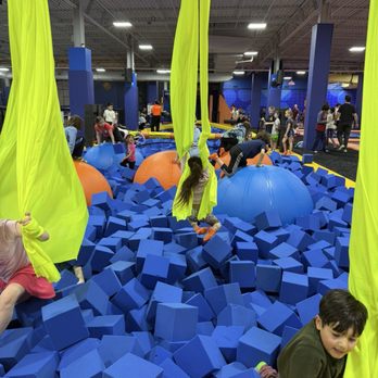 Sky Zone Trampoline Park - Neon trapeze and foam ball pit (tug of war and gladiator jousting section is directly behind) - Trampoline Parks Near Me - Dulles, Virginia