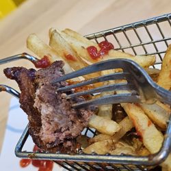 Three Notch'd Craft Kitchen and Brewery - Roanoke - A fork holding a piece of the burger and the basket of fries in the background.
