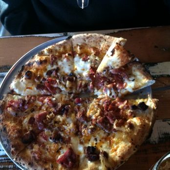 Revelry - MEAT'ZZA -  chili oil, chili flake, tasso ham, Italian sausage, Nueske's bacon, caramelized onions, Grana Padano, gouda. Delicious. - Wine Bars Near Me - Bozeman, Montana