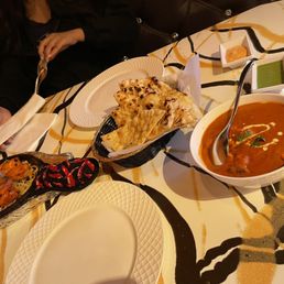 a bowl of soup and a plate of naan bread a bowl of soup and a plate of naan bread
