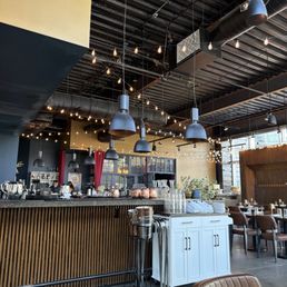 The full service bar and the dining area looking towards the entrance from a window bench seat near the back of the restaurant. The full service bar and the dining area looking towards the entrance from a window bench seat near the back of the restaurant.