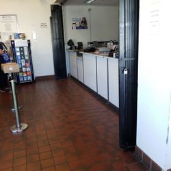 US Post Office - lady has to lug 2 big pillars then put the flag up ...find keys to open the gate,  then help a line of people that have been waiting.