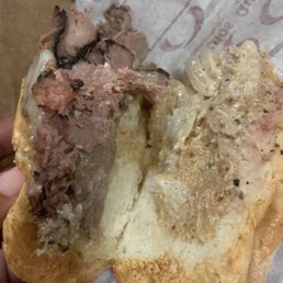 a hand holding a half eaten sandwich a hand holding a half eaten sandwich