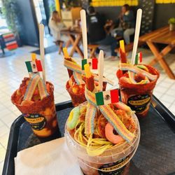 El Esquite - The MANGOLADA (the three) and the LOCO BUCKET! Loco bucket is your choice of chips, Cueritos, Chamoy, tajin, lime, and cucumber! Delicious.
