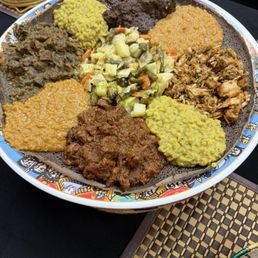 Combo plate with mixed meats and vegetable dishes.