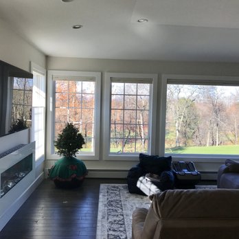 Dwyer Contracting - a living room with large windows and a fireplace - General Contractors Near Me - Saugerties, New York