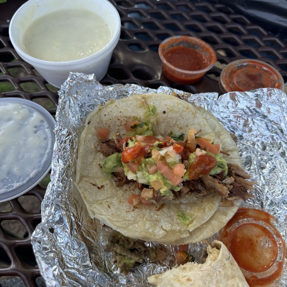 Carnitas tacos and carne Asada burritos with chips and cheese dip