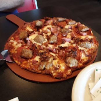 Monk's Bar & Grill - Four meat pizza.  Crust should be crisper.  Tomato sauce needs a good kick of something, to bland. Alittle too much cheese. - Sports Bars Near Me - Middleton, Wisconsin