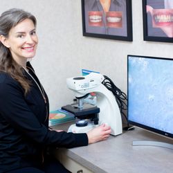 Thomas Frank, DDS - Kat RDH using digital microscope to assess patient slide of bacterial biofilm.