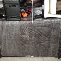 Two Men and a Truck - Armoire on side on concrete