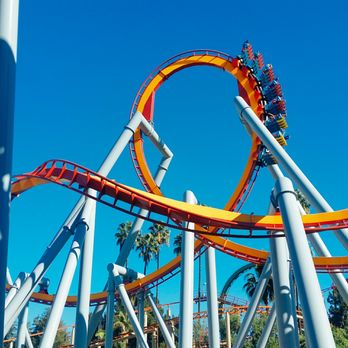 Silver Bullet - A train full of riders navigates the vertical loop, the 1st of 6 inversions. - Amusement Parks Near Me - Buena Park, California