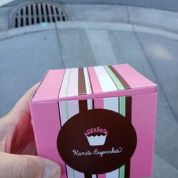 a hand holding a cupcake box a hand holding a cupcake box