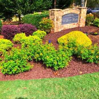 Santoro Scapes - a sign surrounded by flowers - Landscape Architects or Designers Near Me Santoro Scapes - a sign surrounded by flowers - Landscape Architects or Designers Near Me