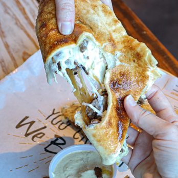 Lit Pizza - Covington - a hand holding a half eaten sandwich - Pizza Near Me - Covington, Louisiana Lit Pizza - Covington - a hand holding a half eaten sandwich - Pizza Near Me - Covington, Louisiana