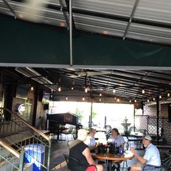 Babe's Tavern & Garden - Covered patio on the side of the building. Heaters against the wall and fans overhead.