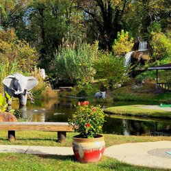 Tropical Gardens Mini Golf - Waterfall and elephant in the pond on the mini golf course.