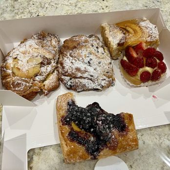 Jerome's Cafe & Bakery - Left to right: almond croissant, chocolate croissant, apple tarte, fresh berry tart, and blueberry croissant on the bottom. - Cafes Near Me - Clearwater, Florida