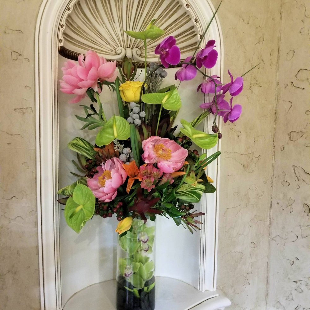 Incredible 2 tier display with orchids draped through the vase and a gorgeous arrangement on top. Incredible 2 tier display with orchids draped through the vase and a gorgeous arrangement on top.