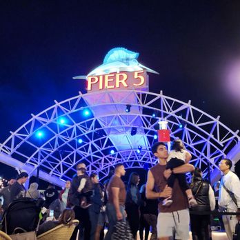 Pier 5 - people standing in front of a pier at night - Bars Near Me - Miami, Florida