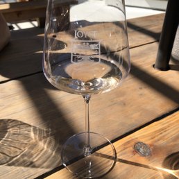 a glass of wine on a wooden table a glass of wine on a wooden table