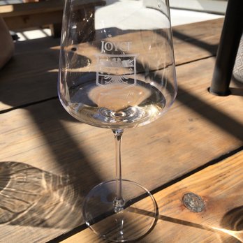 Joyce Wine Company - a glass of wine on a wooden table - Wineries Near Me - Carmel Valley, California Joyce Wine Company - a glass of wine on a wooden table - Wineries Near Me - Carmel Valley, California