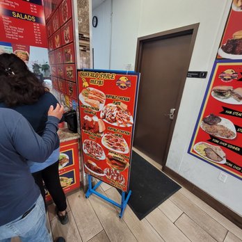 Calibombnia - a woman taking a picture of a menu - Fast Food Near Me - Spring, Texas