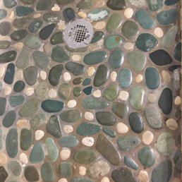 yes that is the color and the dark between the rock is mold or something under in the grout. I should have inspected the bathroom