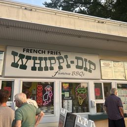 people standing outside of a restaurant people standing outside of a restaurant