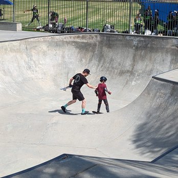 Pacific Skate School - Coach Pat gives a little push as he learns how to go back and forth in the bowl as he build his own momentum. - Skate Parks Near Me - Burbank, California