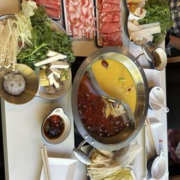 Table with house spicy and chicken soup bases