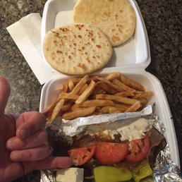a hand holding a sandwich and french fries a hand holding a sandwich and french fries