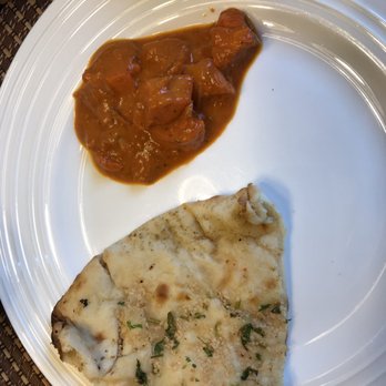 Haveli Indian Cuisine - A piece of Garlic naan with the Chicken Tikka Masala - Indian Near Me - Rochester, New York Haveli Indian Cuisine - A piece of Garlic naan with the Chicken Tikka Masala - Indian Near Me - Rochester, New York