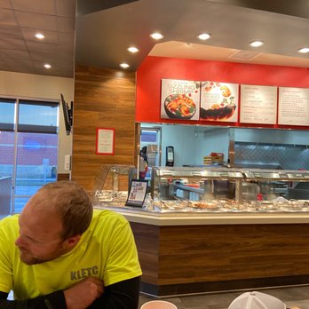 Panda Express - a man sitting at a table eating a meal - Chinese Near Me - Hutchinson, Kansas