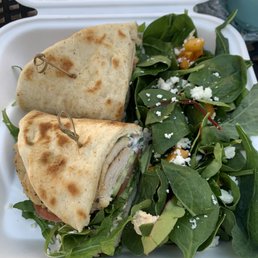 Grilled chicken naan bread wrap with hummus and yogurt sauce. With a side salad Grilled chicken naan bread wrap with hummus and yogurt sauce. With a side salad