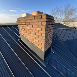 Panda Roof - Clean chimney flashing detail on a metal roof by Panda Roof. Properly finished to help prevent leaks and provide long-lasting protection.