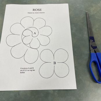 Rochambeau Library - Leathercraft pattern for 3-D Leather Roses by Annie Libertini - A printed pattern for a leather rose craft, showing petal outlines labeled A and B, with scissors nearby on a table. - Libraries Near Me - Providence, Rhode Island