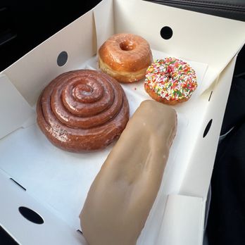 Randy's Donuts - Maple Long John, Cinnamon Roll, Glazed Raised, Vanilla Sprinkles iced cake - Donuts Near Me - Inglewood, California