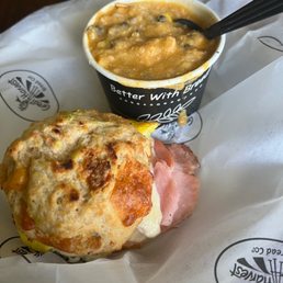 a ham and cheese biscuit with a cup of soup
