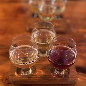 Bushel & Bee Taproom - four glasses of beer on a wooden tray - Cideries Near Me - Leavenworth, Washington Bushel & Bee Taproom - four glasses of beer on a wooden tray - Cideries Near Me - Leavenworth, Washington