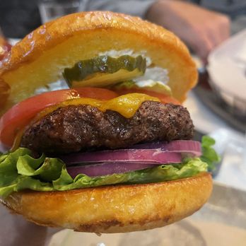 Village Burger Bar - a hand holding a cheeseburger - Burgers Near Me - Plano, Texas Village Burger Bar - a hand holding a cheeseburger - Burgers Near Me - Plano, Texas