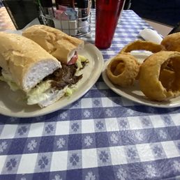 12" Roast beef with brown gravy po-boy with brown gravy, and side of onion rings.