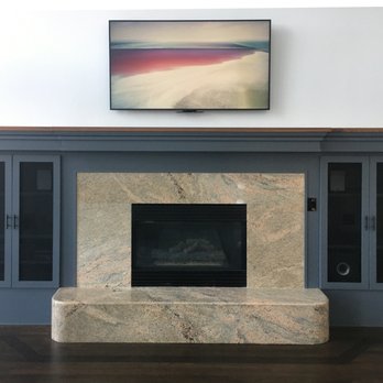 AudioJay - 65" TV on pull-down Mantel Mount above fireplace, speakers and equipment in side cabinets (with doors closed) - Home Theatre Installation Near Me - Boulder, Colorado